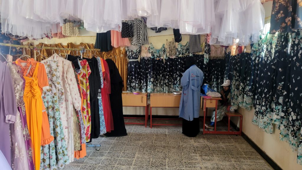 Handmade dresses and clothing displayed at a women's tailoring exhibit in Bani Saad, Al-Mahwit, Yemen