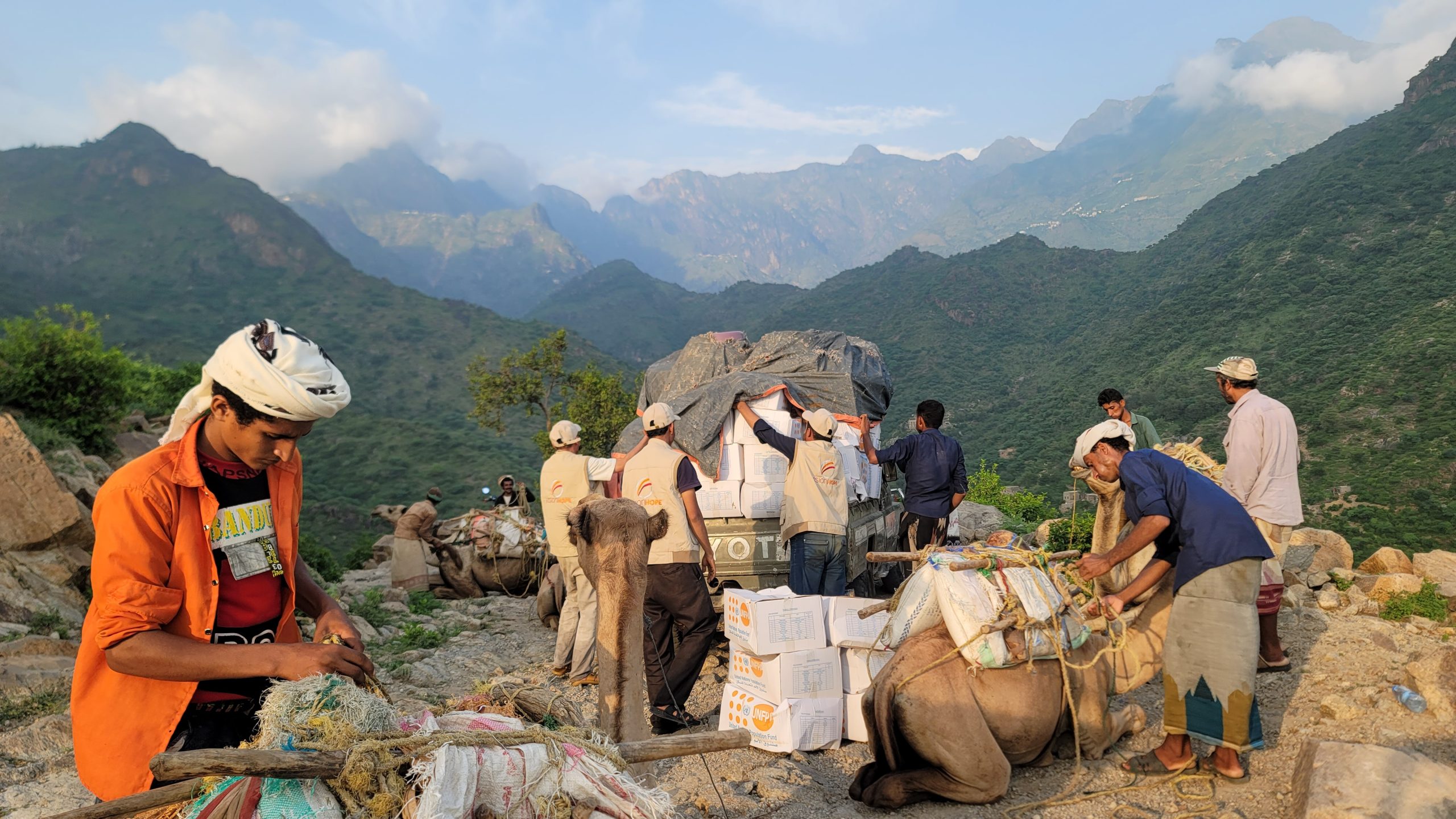 Vision Hope staff loading UNFPA relief boxes onto camels for delivery in the mountains of Milhan, Yemen