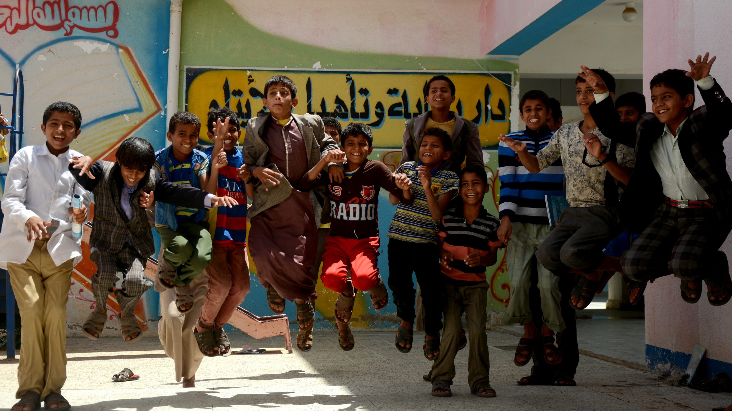 Boys jumping joyfully in front of the orphanage in Yemen supported by Vision Hope
