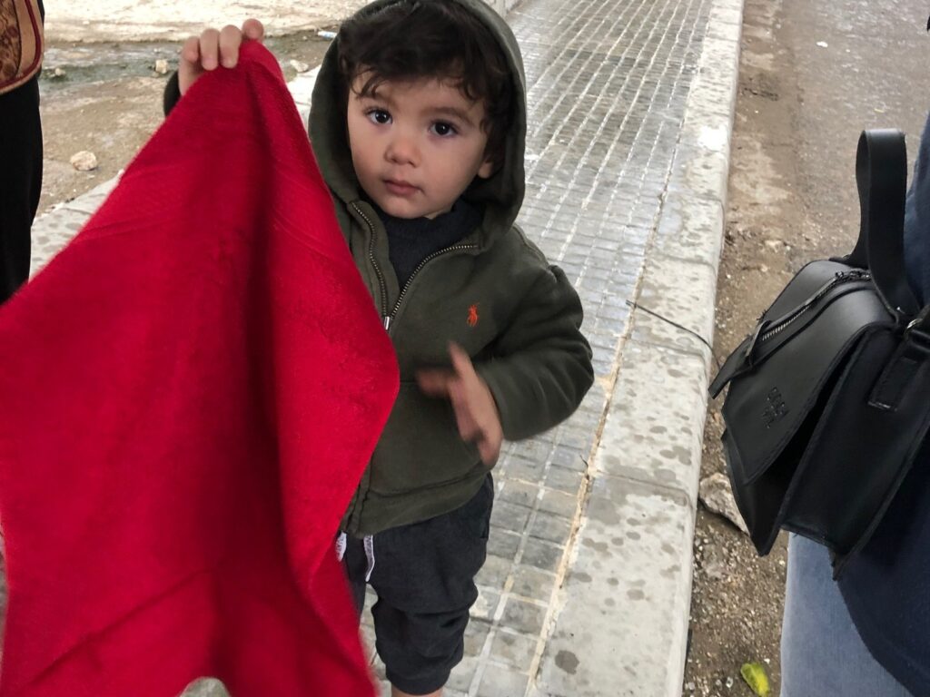 Child receiving a warm blanket during Vision Hope's emergency relief distribution in Lebanon