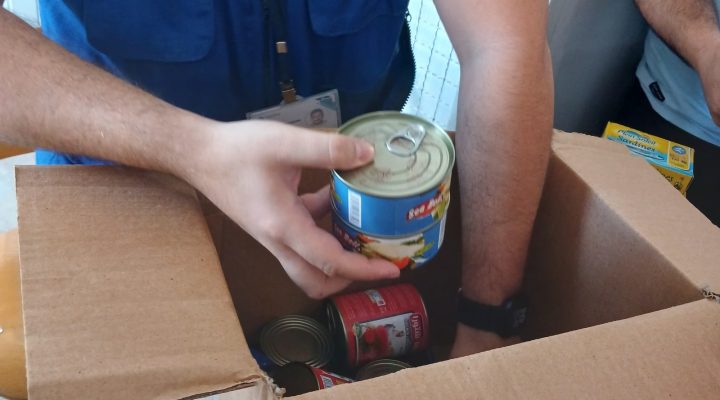 Tabitha relief worker preparing canned food items for distribution
